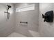 Modern shower with gray tile, a built-in niche, and a sleek black shower head and handle at 5549 Millican Ave, The Villages, FL 32163