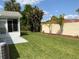 Inviting backyard featuring a well-maintained lawn, privacy fence, and tropical landscaping for outdoor relaxation at 664 San Pedro Dr, The Villages, FL 32159