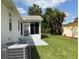 Spacious backyard featuring a patio, tropical foliage, lush lawn, and view of screened in patio at 664 San Pedro Dr, The Villages, FL 32159
