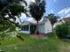 Exterior view of the screened-in lanai and backyard showcasing the well-maintained landscaping at 664 San Pedro Dr, The Villages, FL 32159