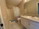 Bathroom with shower/tub combo, white vanity, large mirror and white tile floors at 664 San Pedro Dr, The Villages, FL 32159