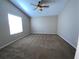 Spacious bedroom featuring neutral-colored walls, plush carpeting, vaulted ceiling, and a large window at 664 San Pedro Dr, The Villages, FL 32159