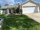 Single-story home with a well-manicured lawn, attached garage, and freshly painted exterior at 664 San Pedro Dr, The Villages, FL 32159