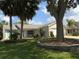 Charming single-story home with well-maintained lawn and landscaping including a tree and several palms at 664 San Pedro Dr, The Villages, FL 32159