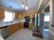 Bright kitchen featuring stainless steel appliances, light wood cabinetry, and white tile flooring at 664 San Pedro Dr, The Villages, FL 32159