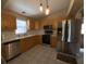 Bright kitchen featuring stainless steel appliances, light wood cabinetry, and white tile flooring at 664 San Pedro Dr, The Villages, FL 32159