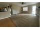 Open-plan living room with window, sliding door and kitchen in background with carpet and hard surface flooring at 664 San Pedro Dr, The Villages, FL 32159