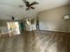 An airy living room with slider glass doors, a kitchen in the background, and carpet throughout at 664 San Pedro Dr, The Villages, FL 32159
