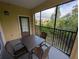 The screened porch offers tranquil views of mature trees with a table and seating for four at 8801 Worldquest Blvd # 4203, Orlando, FL 32821