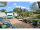 Charming backyard with a swing, brick patio, privacy fence, and abundant potted plants at 97 Hillside Dr, Eustis, FL 32726