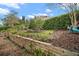 Landscaped backyard featuring terraced planting beds and a well-maintained lawn at 97 Hillside Dr, Eustis, FL 32726