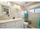 Bright bathroom features double sinks, white cabinetry, framed mirrors, a glass-enclosed shower, and a toilet at 97 Hillside Dr, Eustis, FL 32726