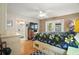 Primary bedroom suite features wood floors, ceiling fan, dresser with a TV, and access to the bathroom and patio at 97 Hillside Dr, Eustis, FL 32726