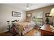 Cozy bedroom boasts neutral walls, wood floors, and ample natural light from the window and a ceiling fan at 97 Hillside Dr, Eustis, FL 32726