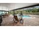 Inviting outdoor space with a covered patio, pool, and meticulous landscaping at 97 Hillside Dr, Eustis, FL 32726