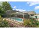 Gorgeous screened-in pool and lush landscaping create a perfect outdoor oasis at 97 Hillside Dr, Eustis, FL 32726