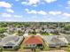 An aerial view showcases a neighborhood of homes with manicured lawns and mature trees at 971 Caribou Way, The Villages, FL 32162
