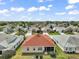 An aerial view showcases a neighborhood of homes with well-maintained lawns and mature trees at 971 Caribou Way, The Villages, FL 32162
