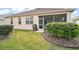 Backyard with lush green grass, landscaping and a screened-in patio at 971 Caribou Way, The Villages, FL 32162