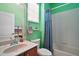 Bright bathroom featuring a combination tub and shower, vanity with mirror and lavatory, and tiled walls at 971 Caribou Way, The Villages, FL 32162