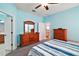 Bedroom featuring blue walls, soft carpet, a ceiling fan, and wooden furniture at 971 Caribou Way, The Villages, FL 32162