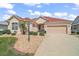 Attractive single-story home featuring a neatly landscaped yard and a welcoming entrance at 971 Caribou Way, The Villages, FL 32162