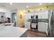 Modern kitchen boasting white cabinets, stainless steel appliances, backsplash, and quartz countertops at 971 Caribou Way, The Villages, FL 32162