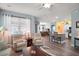 Open-concept living room showcasing hardwood floors, comfortable seating, and a seamless transition to the kitchen at 971 Caribou Way, The Villages, FL 32162