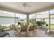 Enclosed porch features views of lush green yard and ceiling fan at 971 Caribou Way, The Villages, FL 32162
