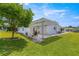 Well-manicured backyard features a covered patio with a pergola and an open yard, perfect for outdoor living at 9773 Se 179Th Pl, Summerfield, FL 34491