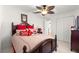 Bedroom featuring a dark wood bed with red accents and a ceiling fan at 9773 Se 179Th Pl, Summerfield, FL 34491