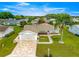 Charming home featuring a manicured lawn, palm tree, patterned driveway, and an attached two-car garage at 9773 Se 179Th Pl, Summerfield, FL 34491