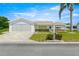 Charming home with a well-manicured lawn, brick accents, two-car garage, and vibrant flowerbeds at 9773 Se 179Th Pl, Summerfield, FL 34491