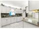 Well-lit kitchen featuring white cabinets, granite countertops, and stainless steel appliances creating a cozy space at 9773 Se 179Th Pl, Summerfield, FL 34491