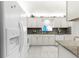 Well-lit kitchen with white cabinetry, stylish backsplash, tile flooring and modern appliances providing a clean aesthetic at 9773 Se 179Th Pl, Summerfield, FL 34491