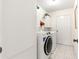 Well-lit laundry room with a GE washer and dryer, tile floors, and storage cabinets at 9773 Se 179Th Pl, Summerfield, FL 34491