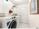 Bright laundry room with modern GE washer and dryer and storage cabinets at 9773 Se 179Th Pl, Summerfield, FL 34491