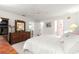 Bright main bedroom with carpet, dark wood furniture, and three access doors at 9773 Se 179Th Pl, Summerfield, FL 34491