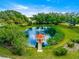 Scenic view of a community pond with a charming gazebo, lush greenery, and surrounding trees at 9773 Se 179Th Pl, Summerfield, FL 34491