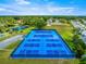 Aerial view of vibrant blue tennis courts, promising recreational opportunities in a well-maintained community at 9773 Se 179Th Pl, Summerfield, FL 34491
