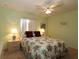 Comfortable bedroom with floral bedding, matching nightstands, and a ceiling fan at 9948 Se 175Th Pl, Summerfield, FL 34491