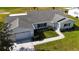 Aerial shot of a white single Gathering home with a large lawn and golf course view at 9948 Se 175Th Pl, Summerfield, FL 34491