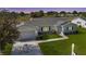 Beautiful white house with a well-manicured lawn and a charming driveway design at 9948 Se 175Th Pl, Summerfield, FL 34491