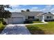 Charming white house showcasing a well-maintained lawn and decorative driveway at 9948 Se 175Th Pl, Summerfield, FL 34491