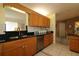 Kitchen featuring granite counters, wood cabinets and an open pass through to living area at 9948 Se 175Th Pl, Summerfield, FL 34491