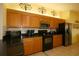 Bright kitchen featuring granite countertops, wooden cabinets and modern appliances at 9948 Se 175Th Pl, Summerfield, FL 34491