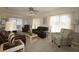 Bright living room with comfortable leather seating, large windows, and access to the patio at 9948 Se 175Th Pl, Summerfield, FL 34491
