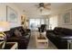 Spacious living room featuring comfortable leather sofas, stylish decor, and ample natural light at 9948 Se 175Th Pl, Summerfield, FL 34491