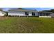 Home's back exterior featuring a well-maintained lawn and a screened-in porch, ideal for enjoying the outdoors at 9948 Se 175Th Pl, Summerfield, FL 34491