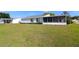 Back exterior view with a well-kept lawn and screened-in porch, perfect for relaxing and enjoying nature at 9948 Se 175Th Pl, Summerfield, FL 34491